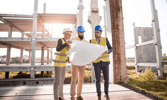 Safety managers discussing a set of plans on a jobsite.