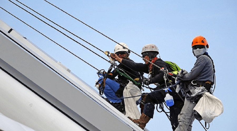 Workers on roof doing fall protection training.