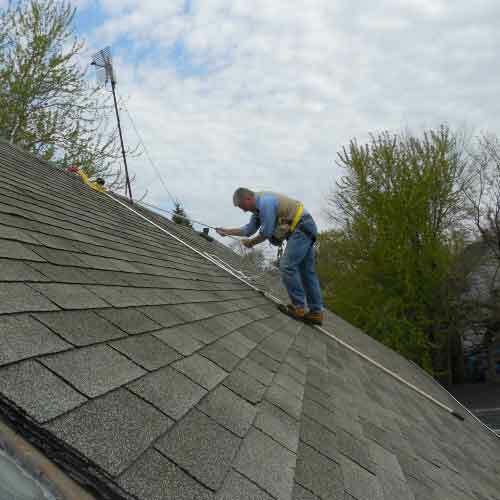 Roofer using a RidgePro hook to work safely on a steep roof.