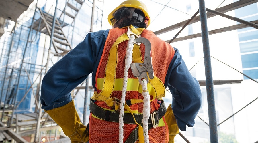 Worker wearing fall protection and safety equipment.
