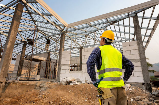 Construction workers assesses a job site.