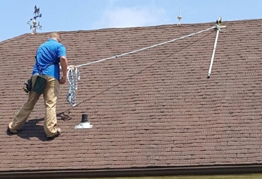 Worker using a RidgePro for anchorage while on a roof.