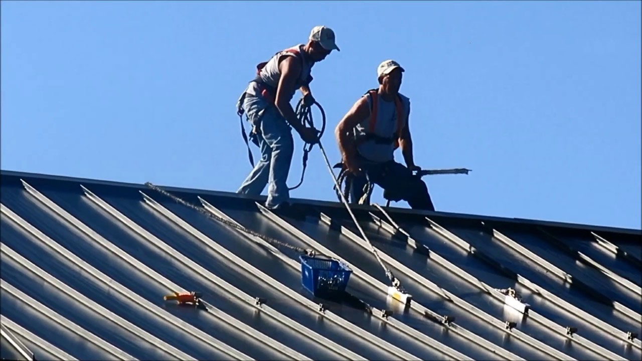 Two roofers using SSRA1 anchor points for fall protection.