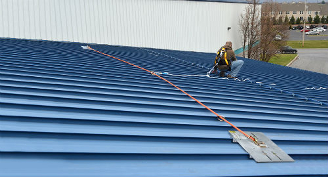 Worker using a SSRA HLL Kit to move freely on a standing seam roof while being anchored.