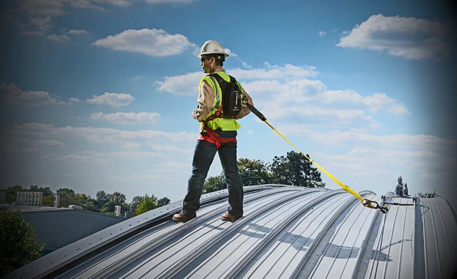 Worker on a metal roof using fall protection.
