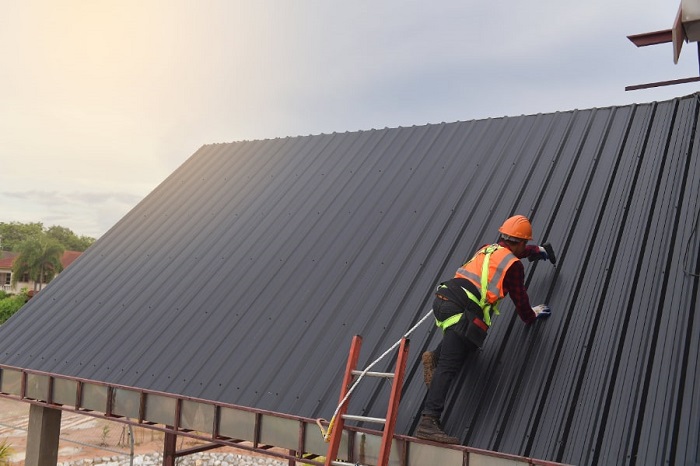 Worker installing a metal roof system.